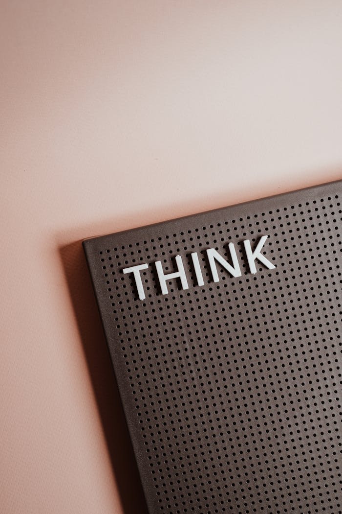 Close-up of a letter board with the word 'THINK' on a soft background.